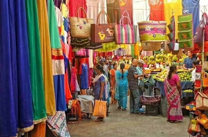 Port Louis market in Mauritius with colourful fabrics, baskets and fruit stalls